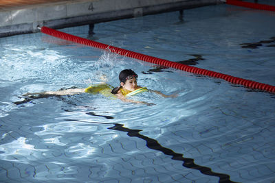 Girl swimming in indoor swimming pool