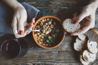 Woman eating mediterranean soup with bread, close-up