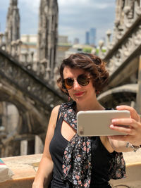 Young female traveler taking selfie above milan duomo.