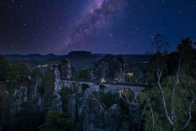 Panoramic shot of buildings against sky at night