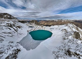 Aerial view of high mountain glacial lake and snow capped mountain peaks. landscape of an alpine