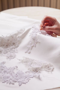 Cropped hand of woman sewing wedding dress