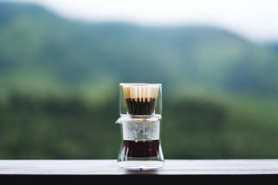 Drip or brewed coffee on wooden table with blurred nature background