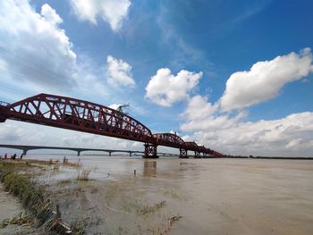 View of bridge over river against cloudy sky