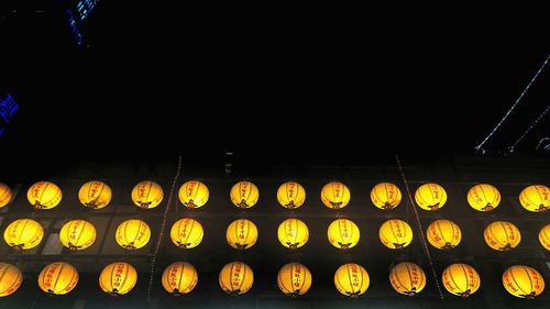 Low angle view of illuminated lanterns in the dark