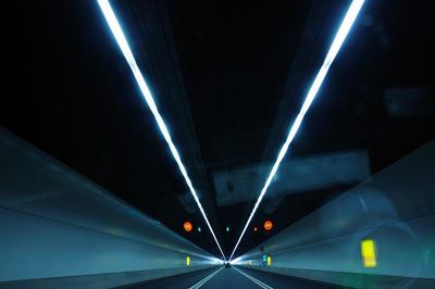 Illuminated tunnel at night