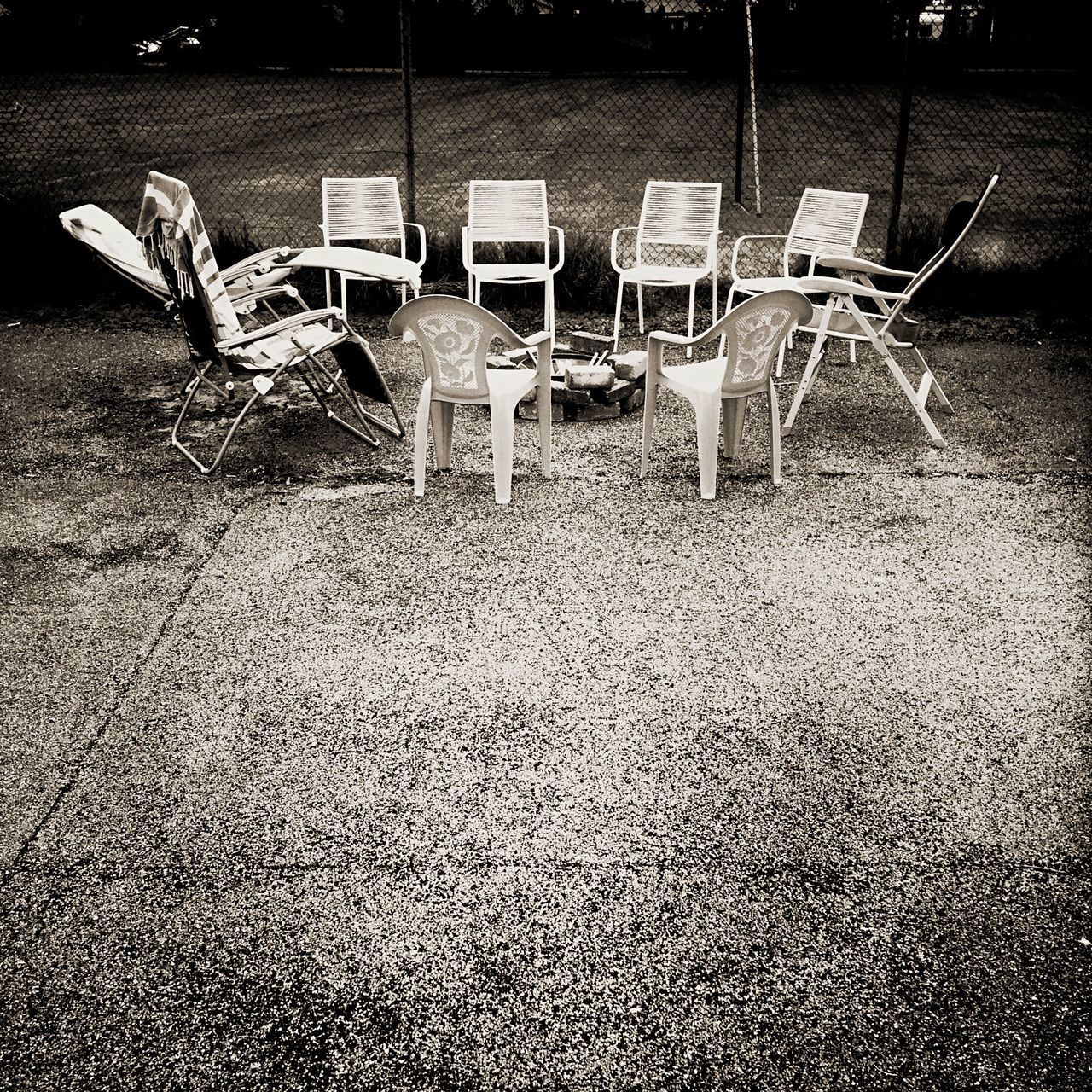 EMPTY CHAIRS IN ROW OF GRASS