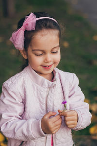 Portrait of cute girl holding pink flower