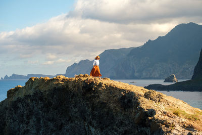 Woman walking over rock against sea