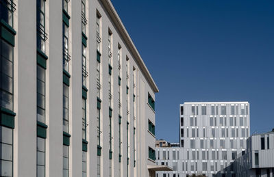 Low angle view of buildings against clear blue sky