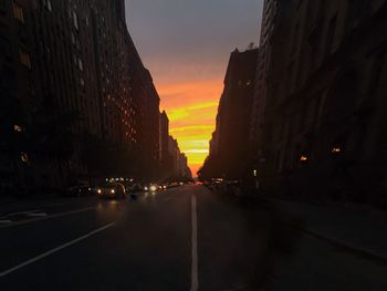 Road passing through illuminated city at night