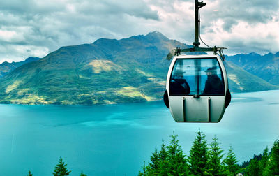 Overhead cable car over mountains against sky