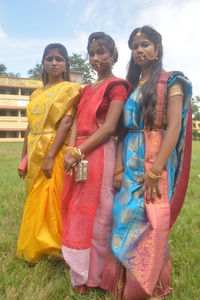 Full length of smiling young woman standing on grass