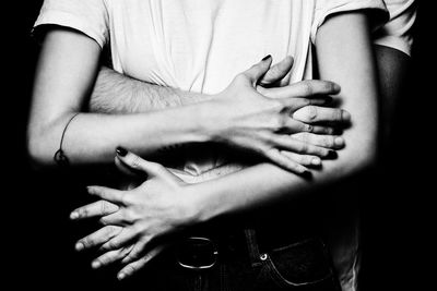 Midsection of woman holding man hands