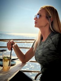 Portrait of young woman using mobile phone at beach