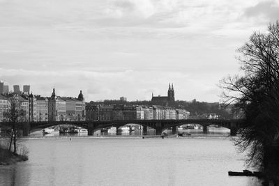 Bridge over river in city against sky