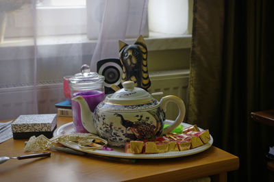 Close-up of tea kettle in plate on table