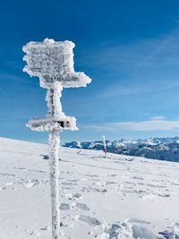 Snow covered land against blue sky