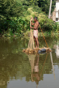 Full length of man standing by lake