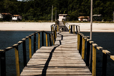 View of wooden bridge over calm water