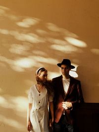 Young couple standing against wall