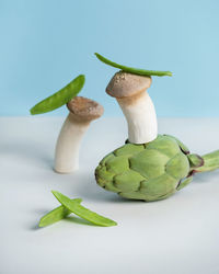 Creative still life composition with artichoke, green peas and pleurotus king oyster mushrooms or