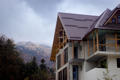 Low angle view of house and buildings against sky