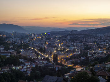 High angle view of illuminated cityscape against sky during sunset