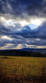 Scenic view of field against storm clouds