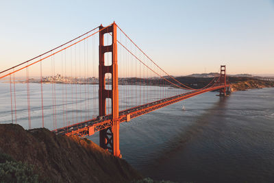 Suspension bridge over river against sky