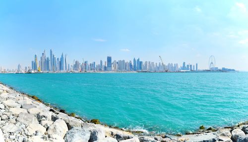 Panoramic view of sea and buildings against sky