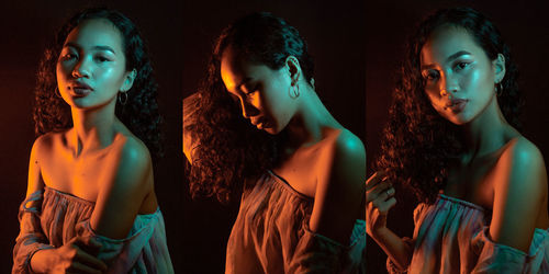 Young woman standing against black background