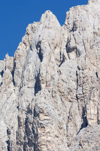 Low angle view of rocks on mountain against clear sky