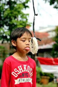 Close-up of boy eating food tied on rope