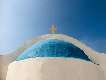 Low angle view of cross on church against blue sky