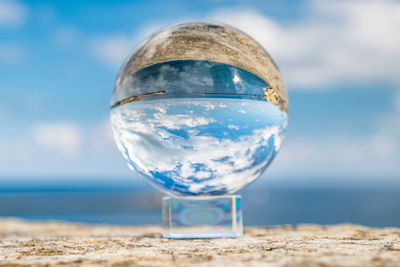 Close-up of glass of water on beach