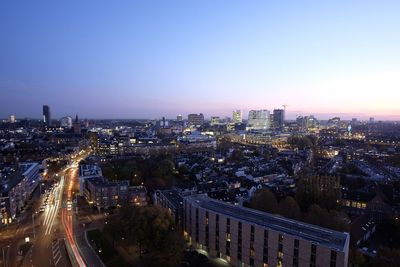High angle view of illuminated city buildings against clear sky