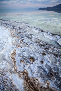 Wet shore by sea against sky