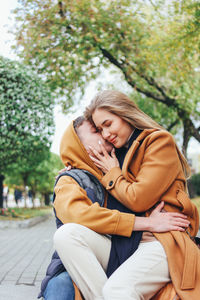 Couple kissing against trees at park