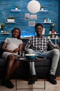 Portrait of smiling young couple sitting outdoors