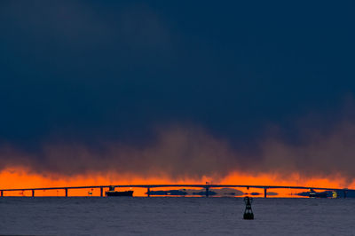 Bridge over sea against sky during sunset