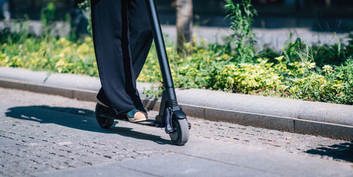 Low section of man walking on footpath in city