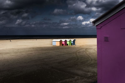 Beach hut by sea against sky