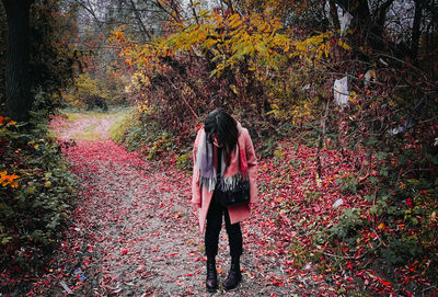 Full length of woman standing by plants during autumn