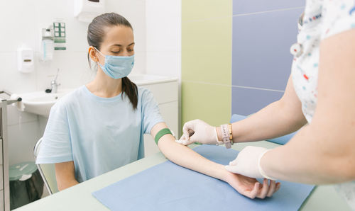 Midsection of doctor vaccinating patient