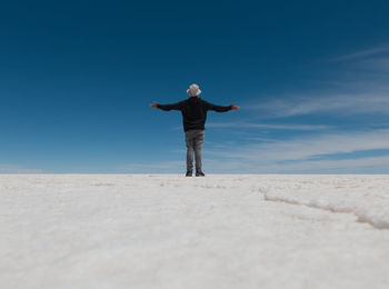 Rear view of man standing on landscape against sky