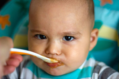 Close-up portrait of cute baby eating