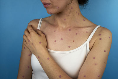 Midsection of young woman applying nail polish