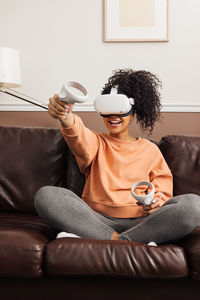 Young woman sitting on sofa at home