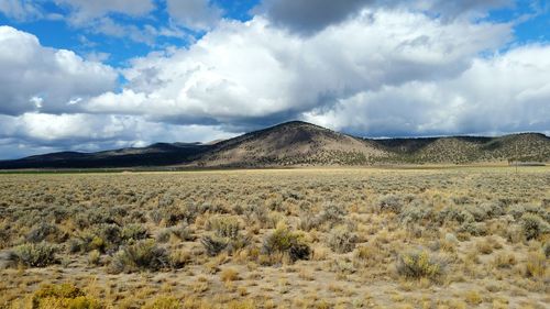 Scenic view of field against cloudy sky